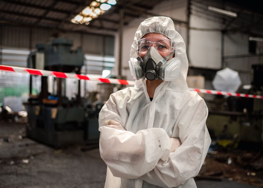 A worker in full safety gear, looking at the camera