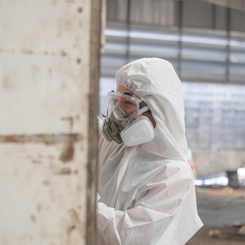 Technician in an air-purifying respirator working to remove asbestos