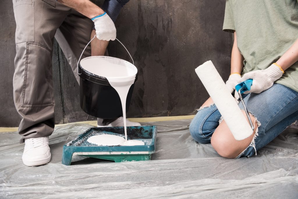 A pair of people pouring paint.